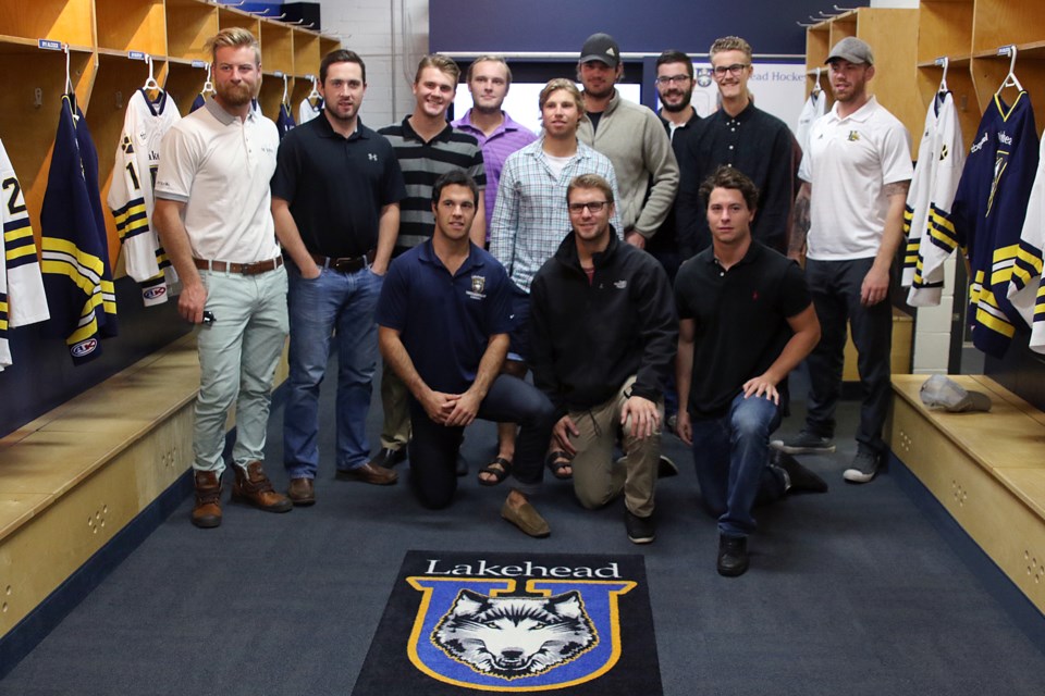 A dozen members of this year's Lakehead Thunderwolves hockey team pose inside their newly revamped dressing room on Tuesday, Sept. 20, 2016. 