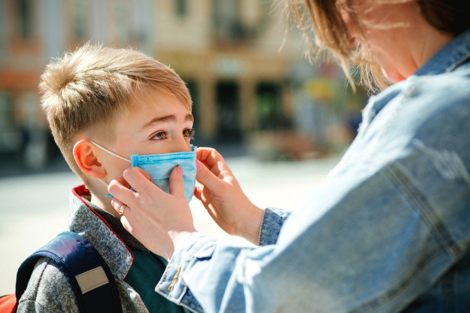 Mother,Puts,A,Safety,Mask,On,Her,Son&#8217;s,Face.,Schoolboy