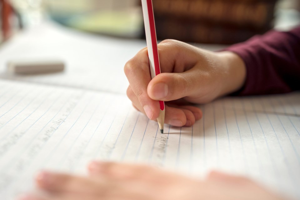 Boy,Writing,In,A,Notepad,Doing,His,School,Work,Spelling