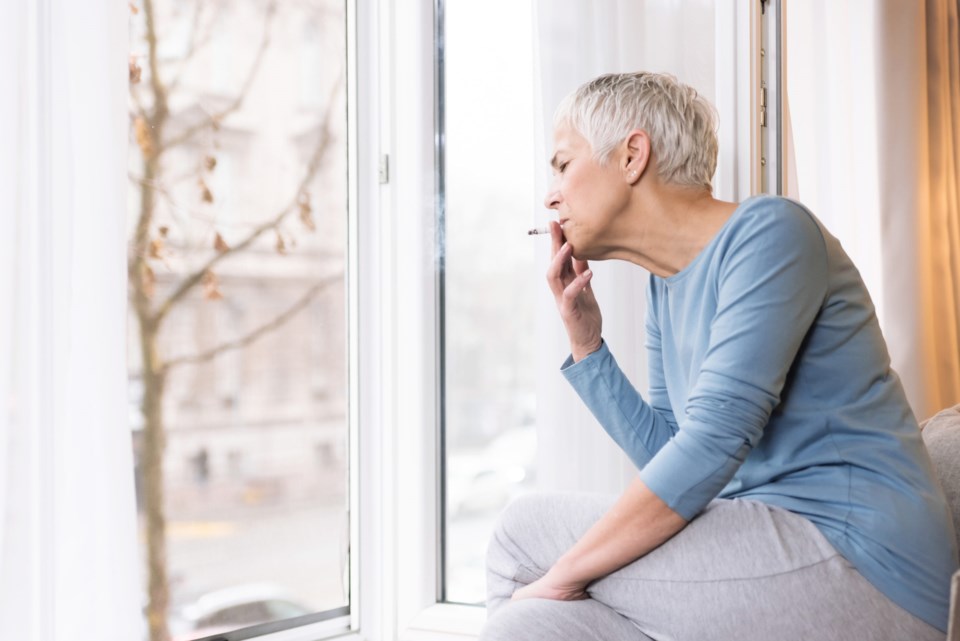 Mindful,Mature,Woman,Sitting,By,The,Window,In,Her,Home