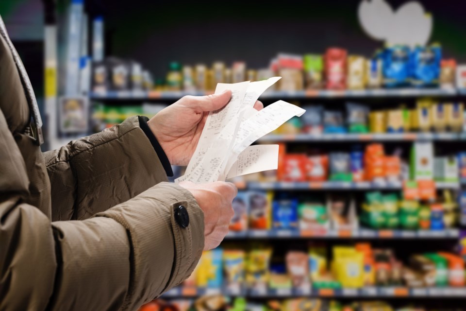 Minded,Man,Viewing,Receipts,In,Supermarket,And,Tracking,Prices