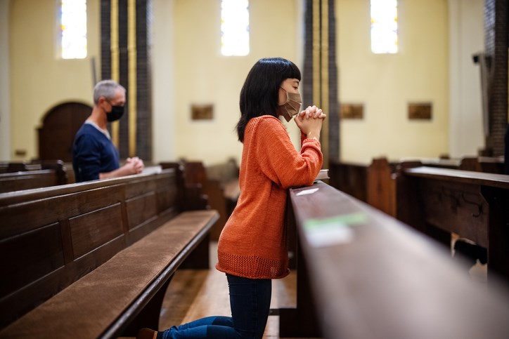 masked worshippers in church pews stock photo