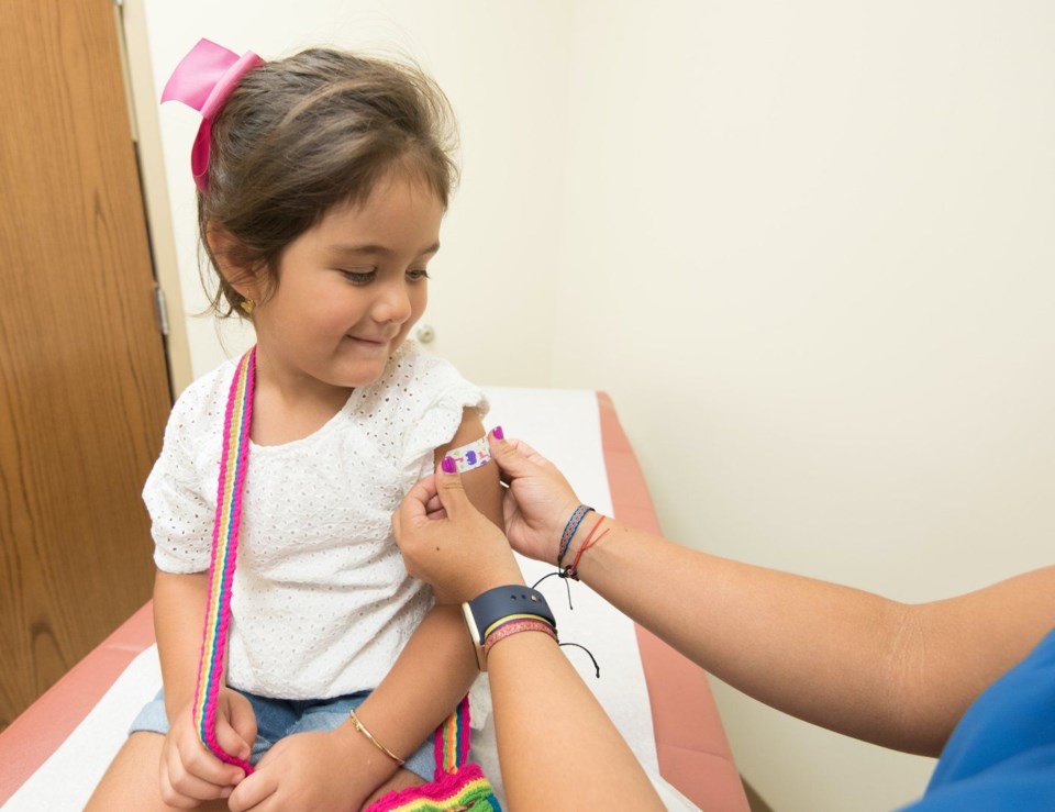 stock photo of young child getting vaccination bandage