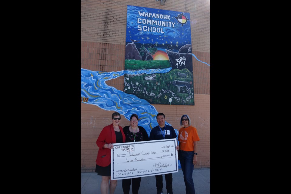 Wapanohk Community School gym teacher Jerry Halcrow, second from right, accepts a $7,000 cheque from Kim Rudolph, left, Cara Butler, second from left, and Kate Roth, right, on May 8.