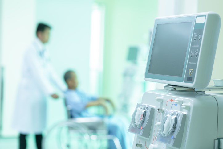 hemodialysis machine with doctor and patient in wheelchair in the background