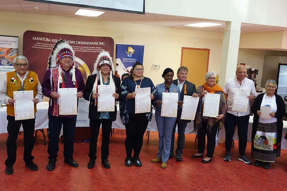 Signatories and witnesses of the declaration to end Indigenous-specific racism in Northern Manitoba’s healthcare system pose with signed copies of the declaration