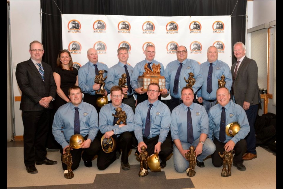 Gary Annett of host Vale Manitoba Operations (back row, left) and Stacy Kennedy (back row, second from left) and Richard Trudeau (back row, right), co-chairs of the Mining Association of Manitoba mine rescue organization, pose with the 2022 Manitoba Mine Rescue Competition winning team from Hudbay Flin Flon, which includes, Tracy Knutson, Dustin Patterson, George Warman, Rob Johnson, Trevor Thurstan in the back row and Joel Chupik, Rian Bayless, Steve MacArthur, Darren Lyhkun and Marshall Manns in front.
