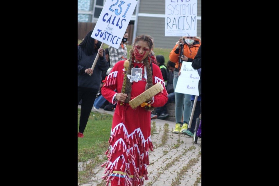 Felicia Lobster, who wears a photo of her sister who was murdered in 2011 around her neck, leads marchers into MacLean Park during Manitoba Keewatinowi Okimakanak’s Missing and Murdered Indigenous Women and Girls memorial walk and candlelight vigil in Thompson Oct. 4.                               