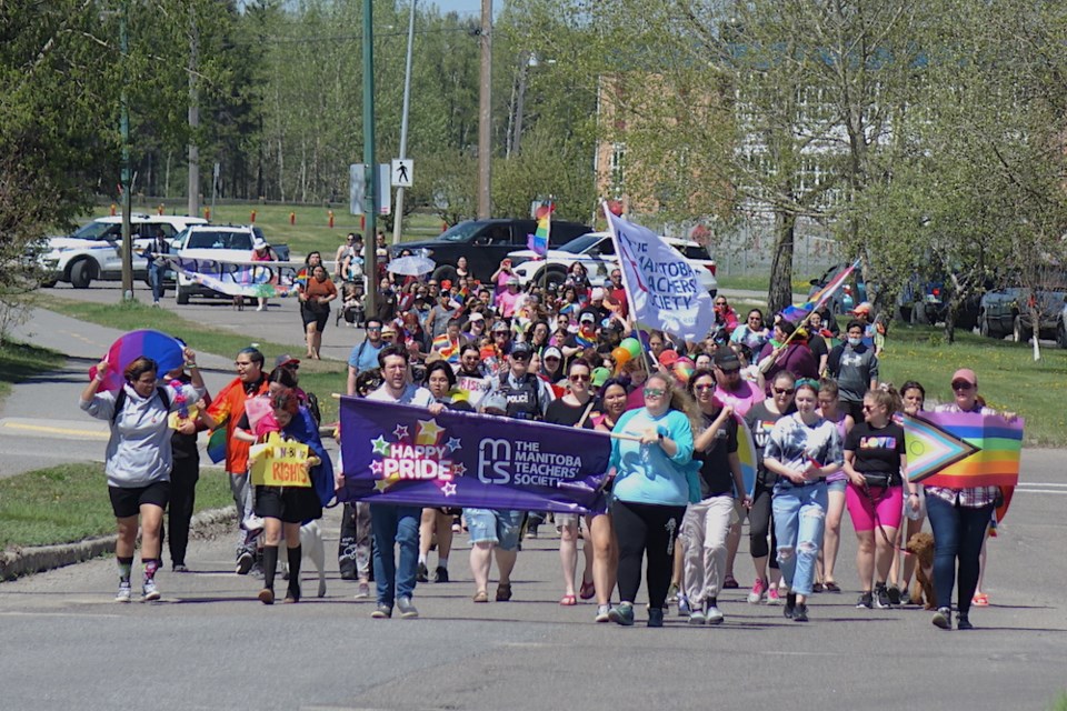  Pride celebrants march up Thompson Drive toward City Hall on June 11.                              
