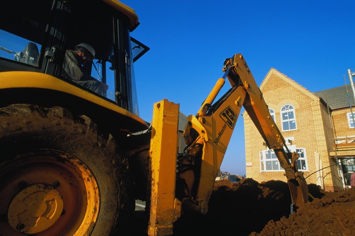 excavator digging outside house