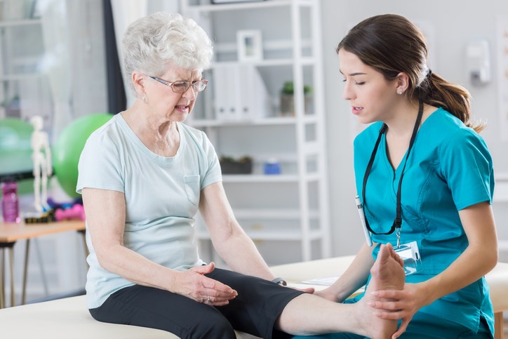 female healthcare worker examines female seniors foot