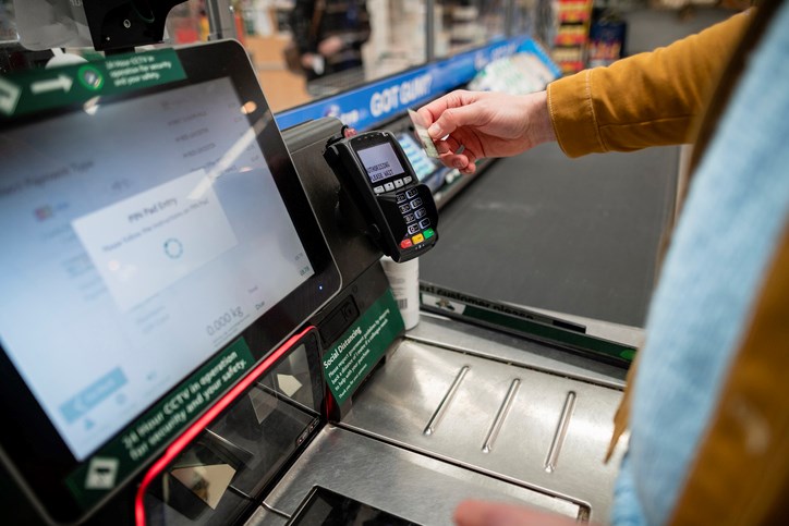 man using supermarket self checkout register