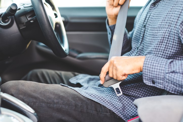 guy in a car doing up seatbelt stock photo
