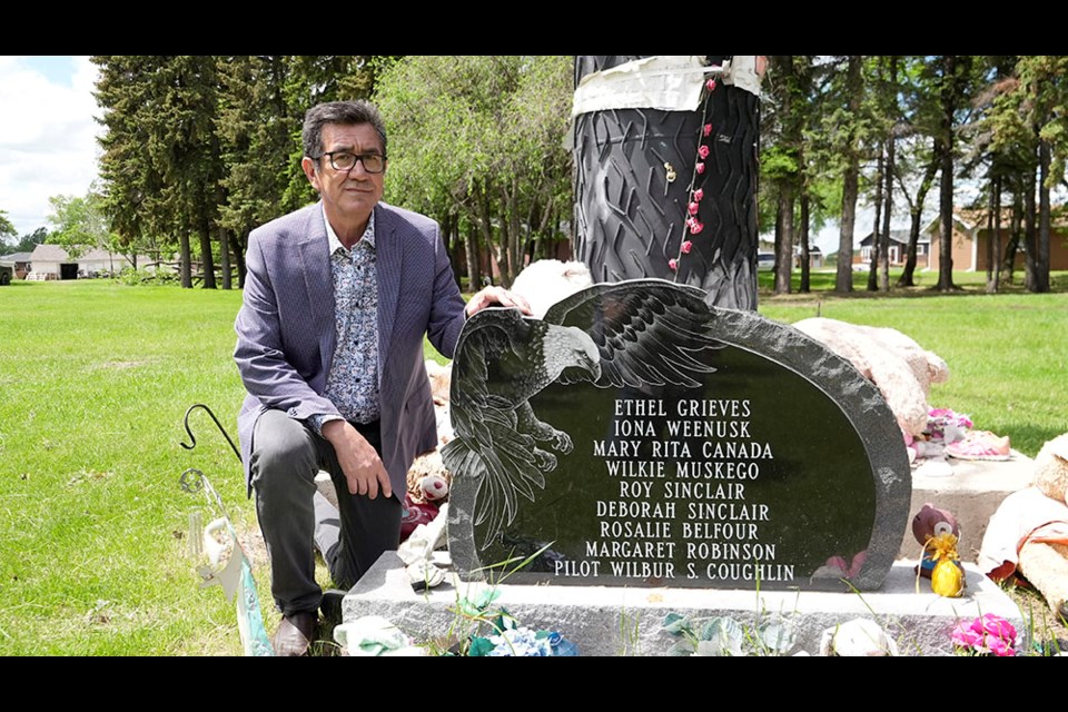 Bunibonibee Cree Nation Chief Richard Hart poses June 15 next to a memorial honouring eight students who were killed in a 1972 plane crash while heading home to Oxford House at the end of the school year.