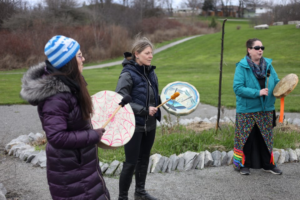 Natalie Blueraven, Michele-Elise Burnett  and Erin Dumo singing and drumming during the opening ceremony at the  Thorold Indigenous Unity Garden. 