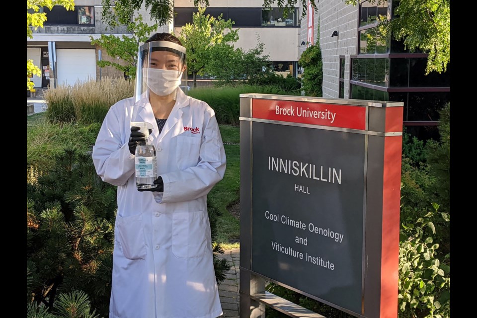 hufen Xu, Analytical Services lab Technologist at Brock’s Cool Climate Oenology and Viticulture Institute (CCOVI), with a bottle of the hand sanitizer created through a partnership between CCOVI and Dillon's Small Batch Distillers. Photo provided by Brock University