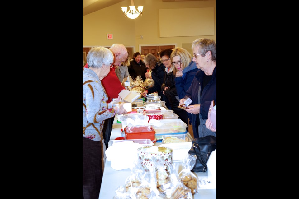 Church volunteers (l) manned the tables as dozens of patrons tried to decide which of the dozens of delicious treats they would take home. Bob Liddycoat/ThoroldNews