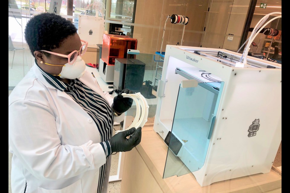 Brock University Makerspace Co-ordinator Tabitha Lewis looks over a 3D printed face shield mount. Brockâs Makerspace has started building face shields that will be given to front-line health-care workers in Niagara. Photo: Supplied