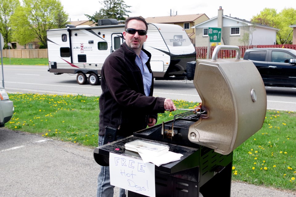 Yard sale organizer Darryl Murphy barbecued free hot dogs in exchange for cash donations to Community Care. Bob Liddycoat /Thorold News