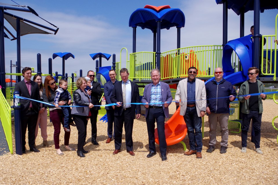 Helping with the ribbon cutting ceremony at the official opening of Gil Gordon Park are: (l-r) Eric Gordon, Hannah Fischer, Meaghan Vendromin, John Vendromin, Diane Gordon, Emmett Vendromin, Adam Vendromin, Nathan Gordon, Glen Gordon (cutting the ribbon), Mayor Terry Ugulini, Thorold CAO Manoj Dilwaria, Councillor Ken Sentance, and Colin Vendromin. Bob Liddycoat / Thorold News 