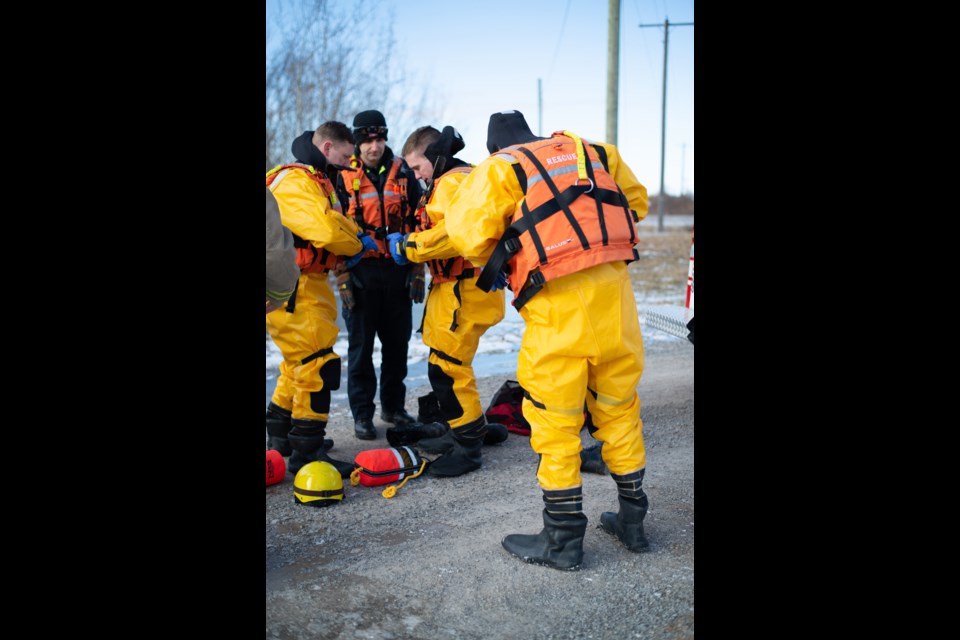 Firefighters Brad Reed (l) and Park Reilly (r) make sure every zipper is zipped and flap folded on their dry suits before entering the water as firefighter and Technical Reserve Lead Mark Todorov (c) checks their work. Doug Youmans for ThoroldNews