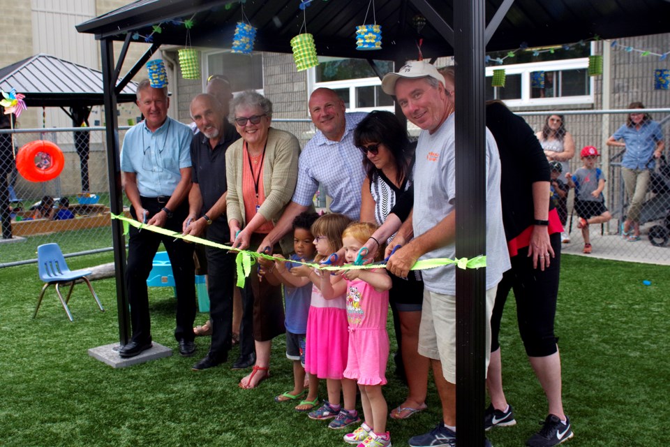 Kids from the TCAG day care helped officials cut the ribbon including: (l-r) Mayor Terry Ugulini, Regional Councillor Tim Whalen, Thorold Councillor and TCAG Board member Ken Sentance, Darlene Edgar, director of family services at the Niagara Region, Dan Pelletier TCAG E.D., TCAG board president Denise Palomba, Tim Proctor of Turf Net Sport Supplies and Child care director Shelly Damude. Bob Liddycoat / Thorold News