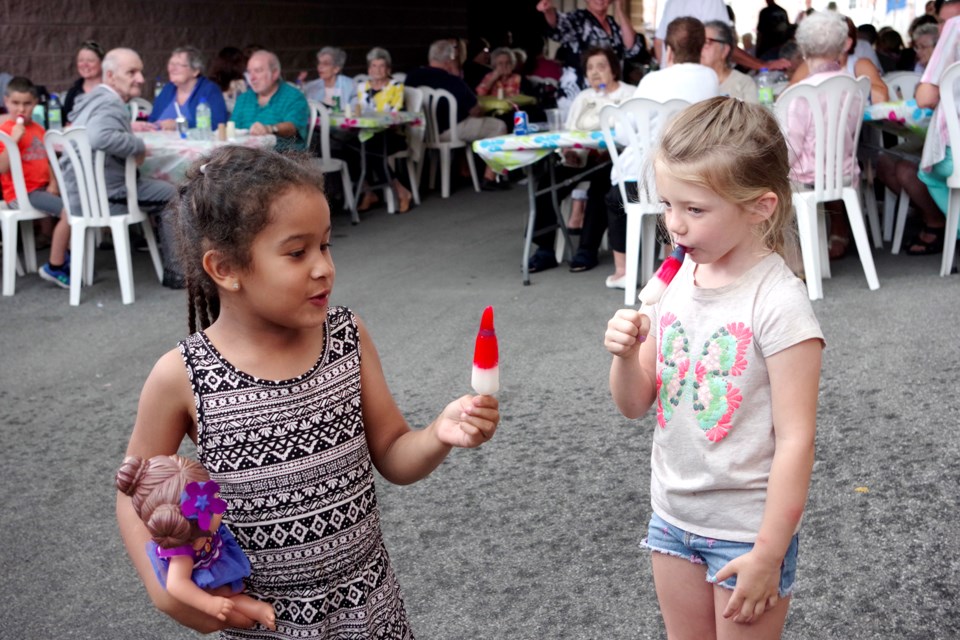 Carling Kenny (left) and Alice Wilson cooled off with popsicles at the annual Cobblestone family barbecue held Friday. Bob Liddycoat / Thorold News