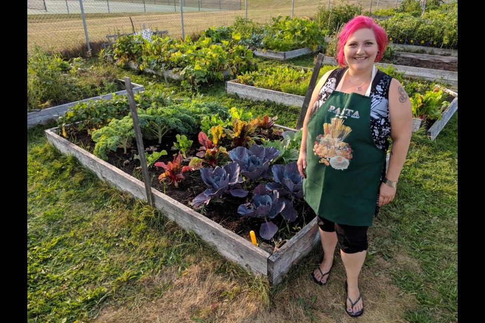 Katrena Pelchat, who operates TWIG Timmins, stands next to one of her plots in the community garden. In collaboration with TWIG, Anti-Hunger Coalition Timmins grows food for emergency food shelters and organizations. Supplied photo.