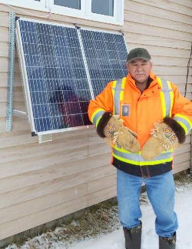 William Carey Sr. with his 300 Watt solar panel he installed at his house in Moose Factory. 