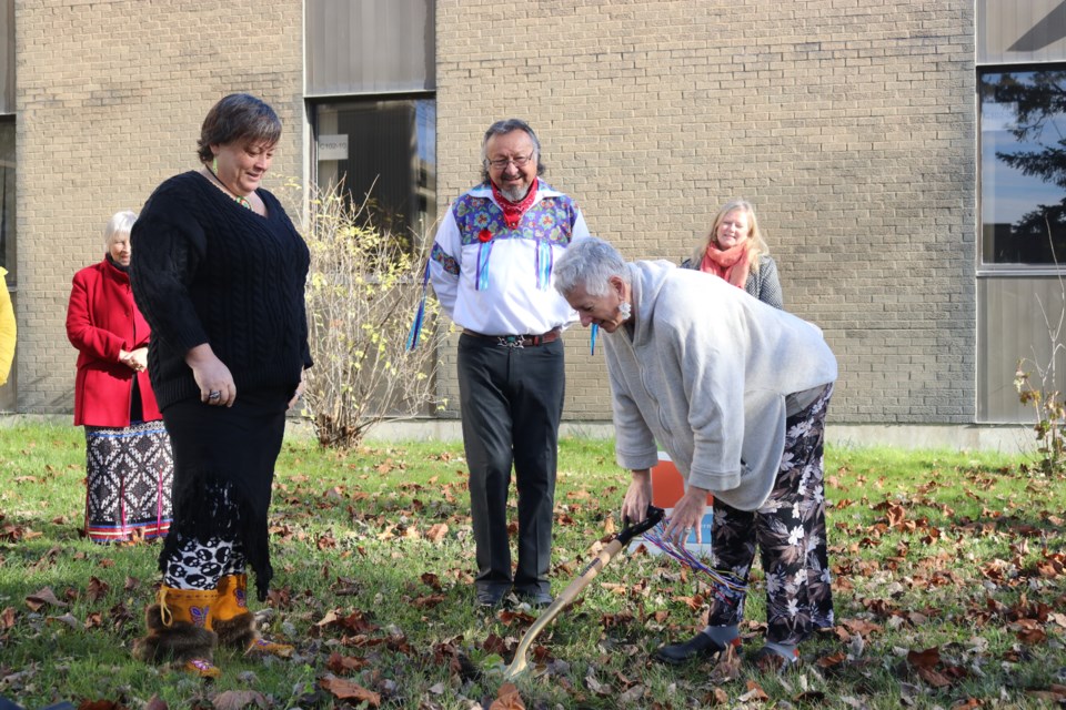 Northern College president Audrey Penner breaks ground as the manager of Indigenous services and initiatives Trudy Wilson and Elder Morris Naveau look on.