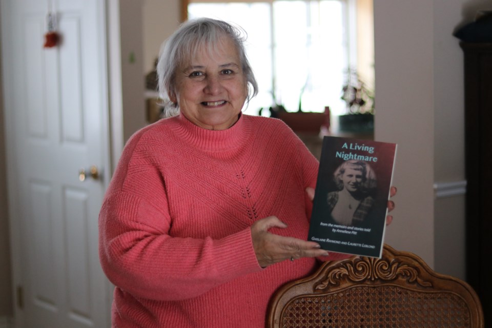 Ghislaine Raymond holds the book she co-wrote with her sister Laurette Leblond. The book is about Raymond's friend and mentor Anneliese Pitt and is titled 'A Living Nightmare: From the memoirs and stories told by Anneliese Pitt'