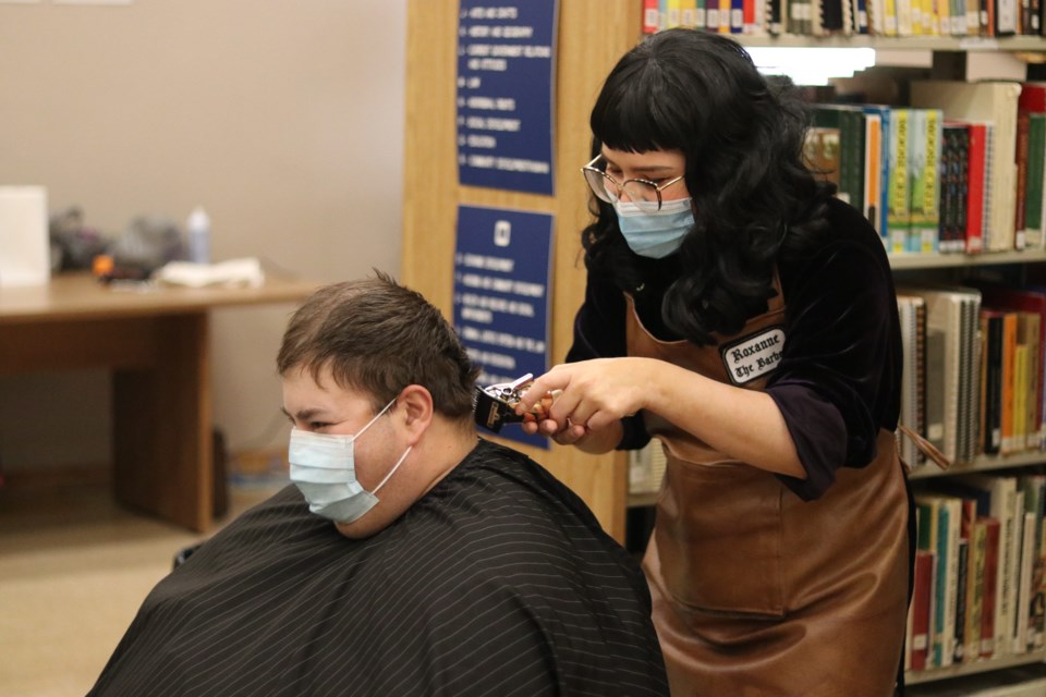 Barber Roxanne Zarudenec gives a haircut to Jordan Corbiere during the charity event held at the Ojibway and Cree Cultural Centre Dec. 6.