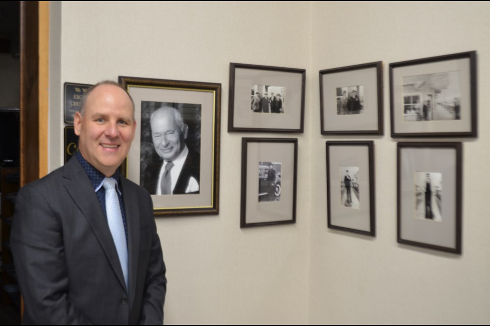 Darren Taylor stands next to a photo of his great grandfather, Max Steinberg, the founder of Steinberg & Mahn Ltd. The store celebrated its 100th anniversary in Timmins in 2019. (Wayne Snider for TimminsToday)