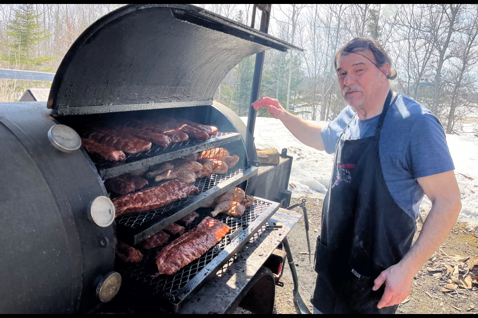 Dale Dupras, owner of Get Ribbed Smokehouse and BBQ, shows off a batch of ribs and chickens cooking. He has entered his sixth year of offering authentic southern barbecue in Timmins.