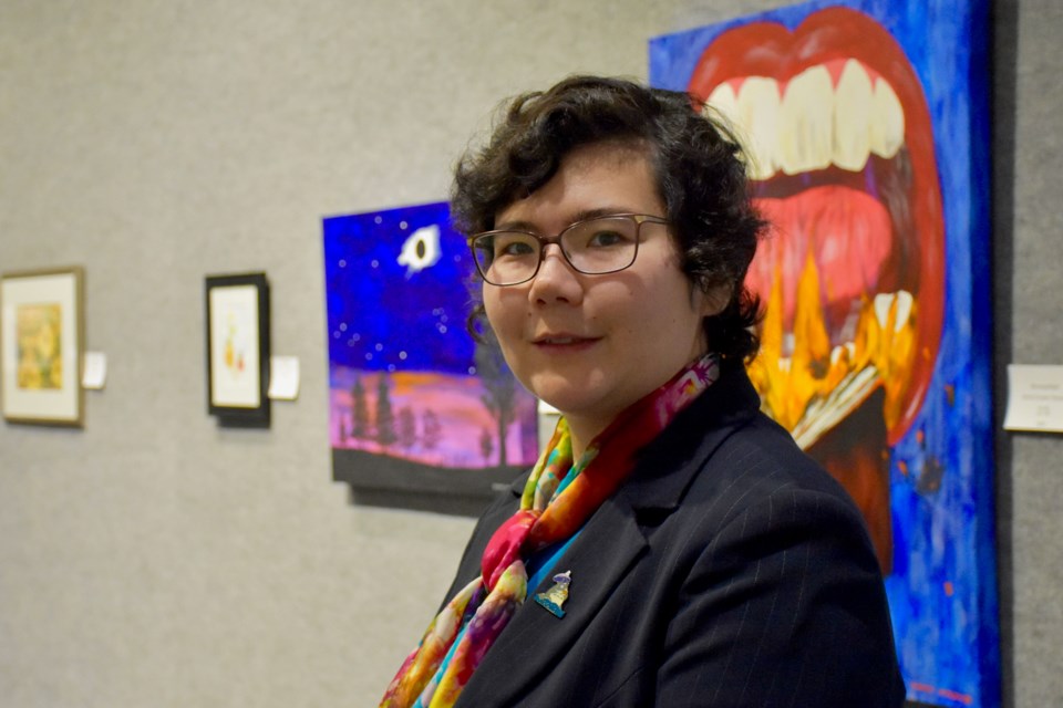 Porcupine Art Club president Karina Douglas-Takayesu with her work at the Dark in the Light art exhibit at the Timmins Museum. Maija Hoggett/TimminsToday