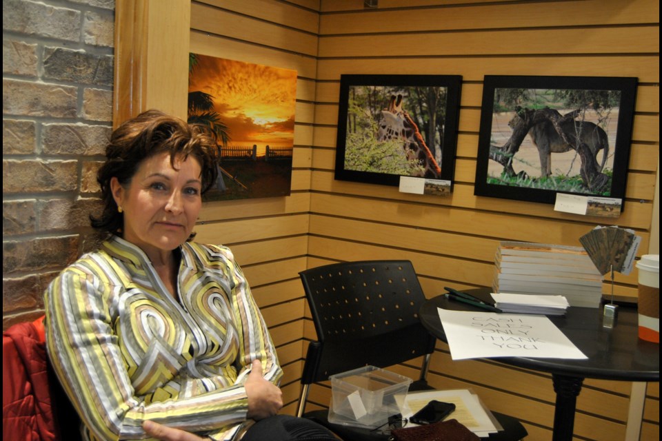 Anne Pelletier, author of Healing My Cracked Heart in Africa, at the Coffee Warehouse in Timmins surrounded by some of her photographs of her December journey to Africa. Frank Giorno for TimminsToday.