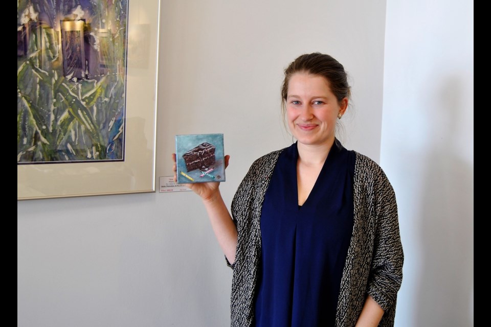 Katelyn Malo, owner of Black Spruce Gallery on Pine St. S., holds up a sample of a 5