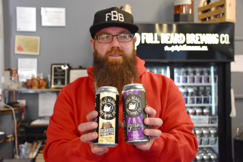 Full Beard's Jonathan St-Pierre with the two beers — Five O'Clock Shadow and The Bearded Prospector — that are being sold in eight Beer Stores in Northern Ontario. Maija Hoggett/TimminsToday