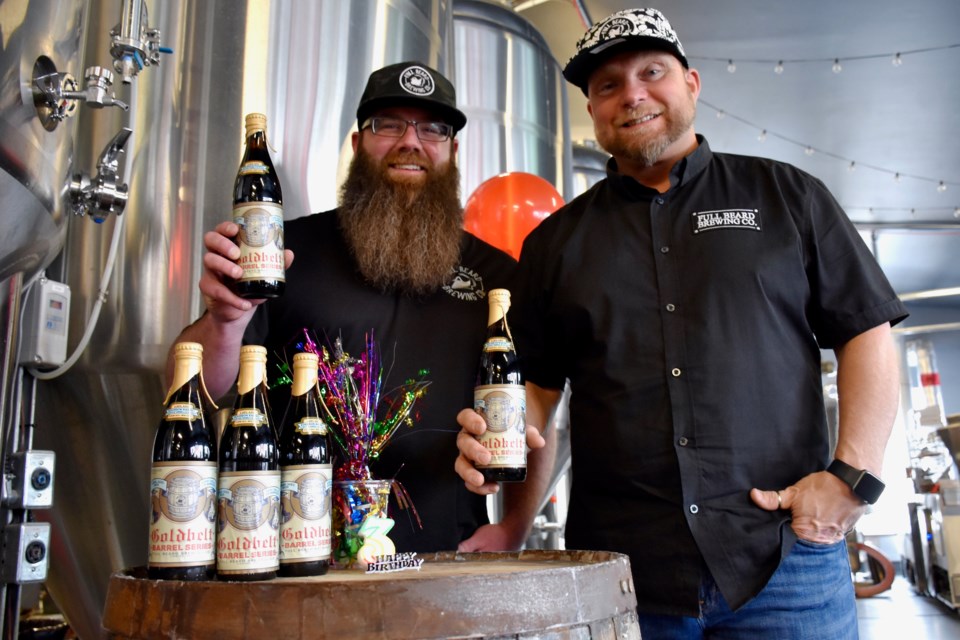 Full Beard Brewing's Jonathan St-Pierre and Benjie Potvin with the limited-edition beer that's being released Jan. 31 to celebrate the brewery's third anniversary. The Goldbelt barrel series beer has been aged for a year in a bourbon barrel. Maija Hoggett/TimminsToday