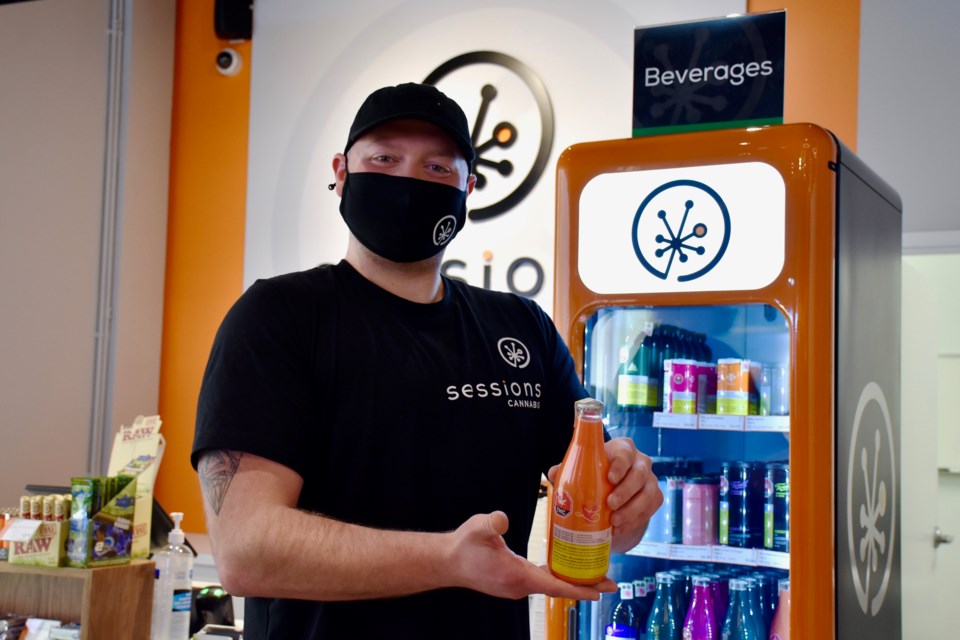 Sessions Cannabis acting manager Jesse Prior showcases the beverages available at the new shop.