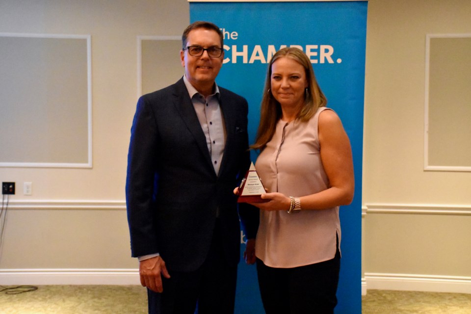 Interfor's Monique Koski accepts a Service Award from The Chamber's outgoing president Rob Knox.