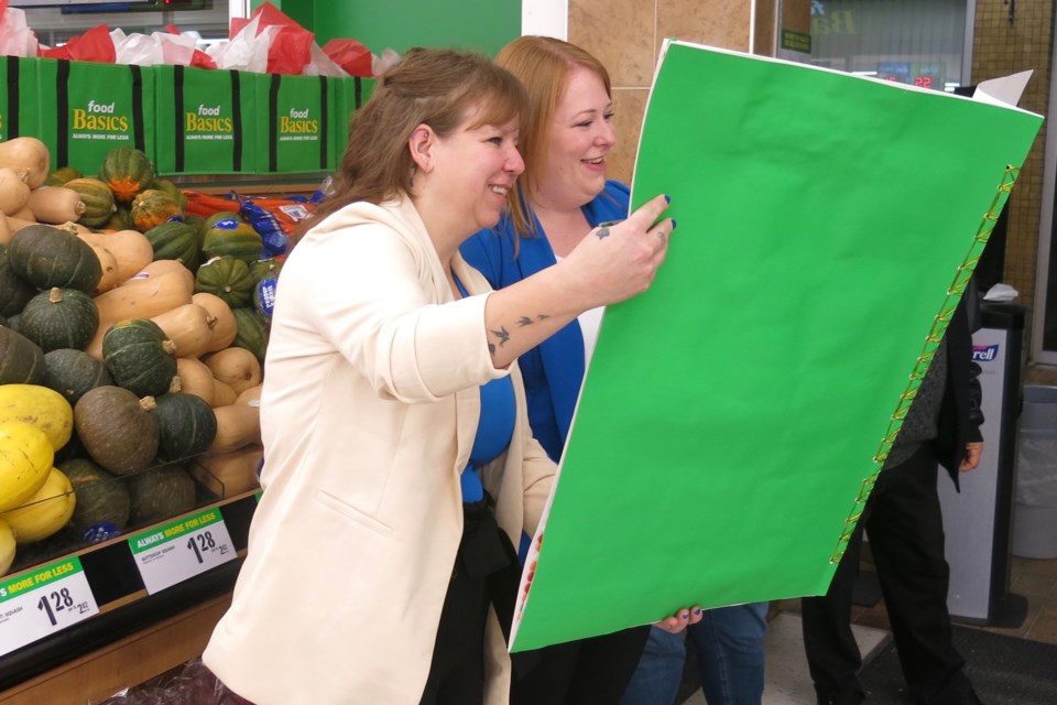 Food Basics manager Kelly Summers and assistant manager Stacey Theriault read the card of thanks from the community.