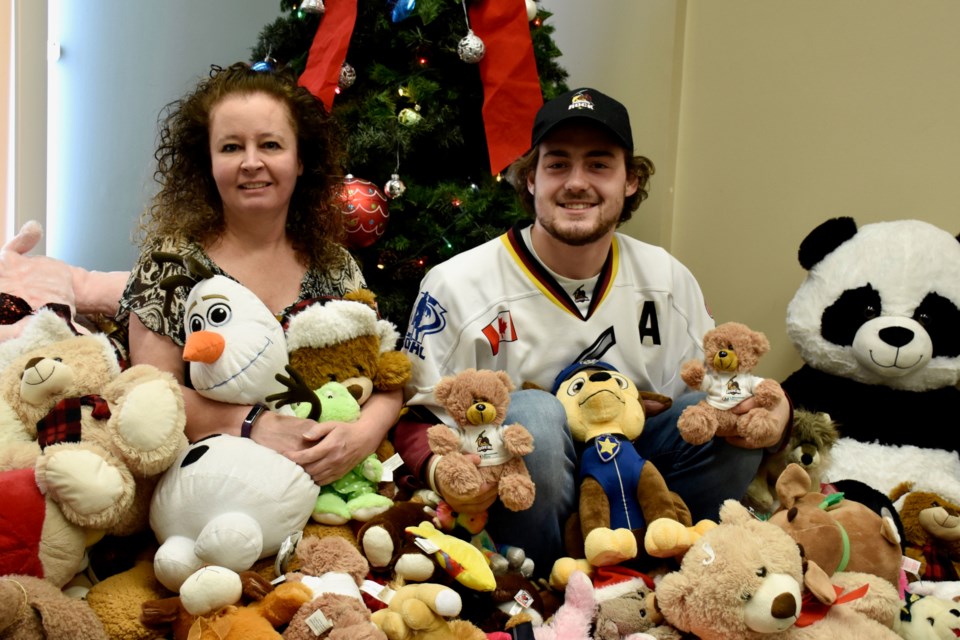North Eastern Ontario Family and Child Services training co-ordinator Tina Kerr-Hardy and Timmins Rock defenceman Grant McClellan with the teddy bear toss donations. Maija Hoggett/TimminsToday 