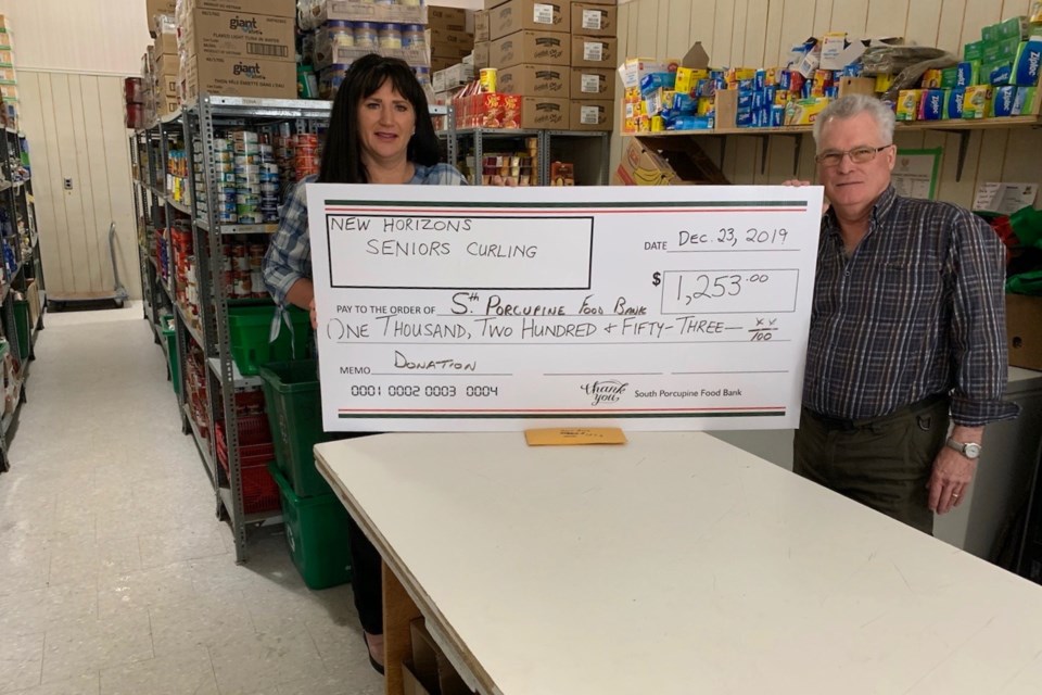 South Porcupine Food Bank president Melissa Narduzzi accepts a $1,253 donation from Wayne Jaszan of the New Horizons Seniors Curling League. Supplied photo