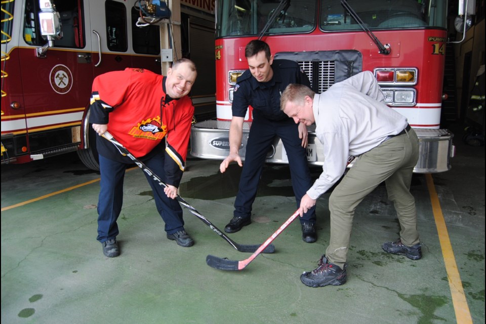Firefighter Buzz Wawrzaszek (left with red jersey) faces off against Dr.Rick Kvas (right) as they announce a charity hockey game between firefighters and the doctors on April 10, 2016