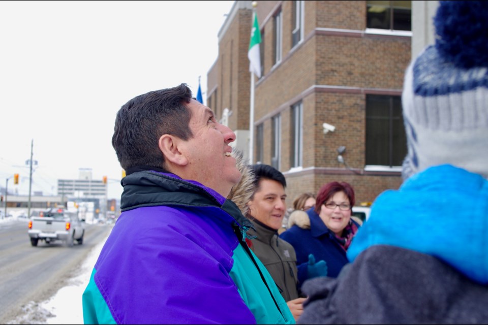 Christian Salguero, who is part of a small group from Bolivia touring Timmins this week, watches as his country's flag is raised at city hall. Maija Hoggett/TimminsToday
