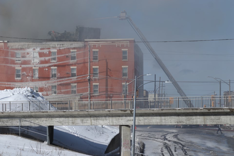At the corner of Spruce Street and Algonquin Blouvelard, fire crews battle a fire on the roof of the Empire Complex.