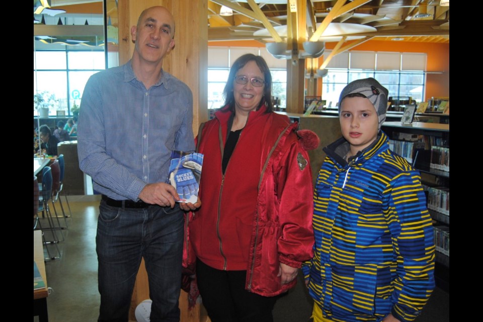 Author David Shuy (left) presenting signed copy of his book Rocket Blues to Aaron Shaw and his mother Christine Seguin. Frank Giorno for TimminsToday