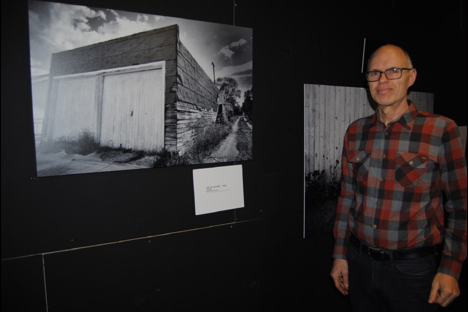 Carlo De Lorenzi by his photograph of Edwin Lucyk's double door garage in a Schumacher laneway. It was this garage that inspired De Lorenzi to photograph Timmins' garages. Frank Giorno for TimminsToday