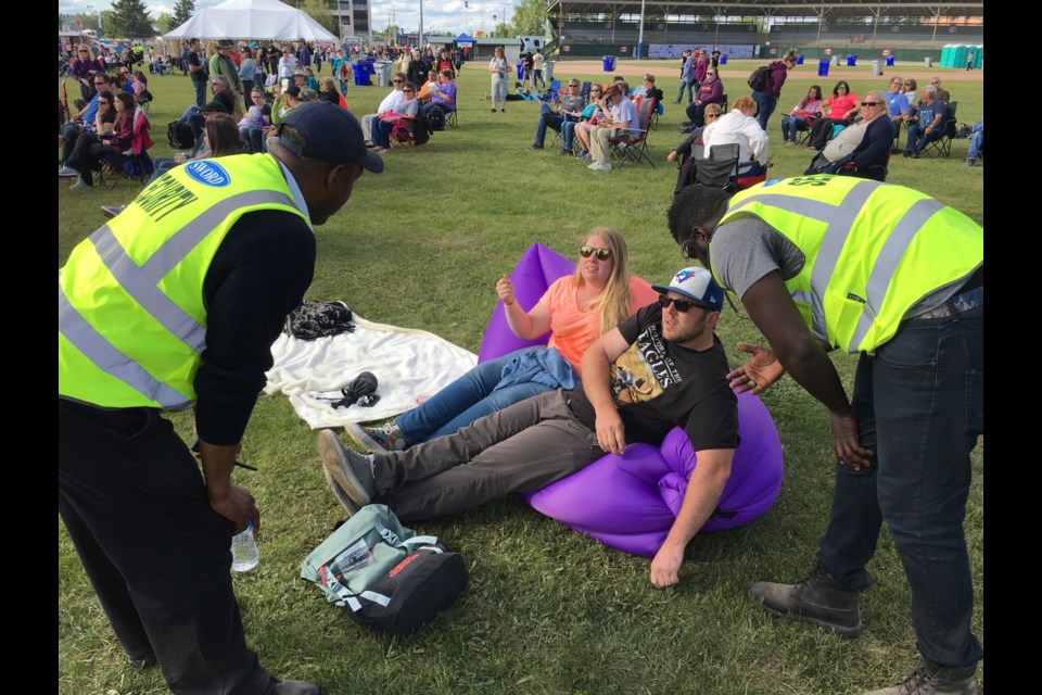 A couple gets the gears from event security personnel for sitting on a small inflatable couch on Monday afternoon at Stars and Thunder. Andrew Autio for TImminsToday